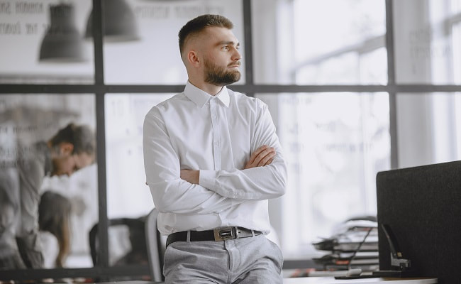 Man in business clothes looks away while thinking