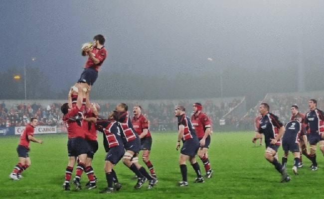 Man held up by team members in rugby ruck