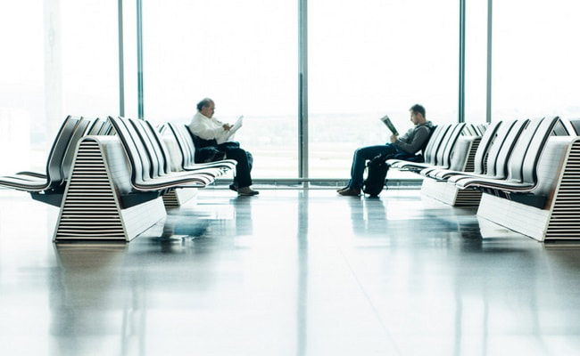 Two adults waiting at an airport
